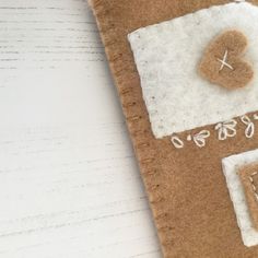 two pieces of felt with hearts and crosses on them sitting on top of a piece of paper