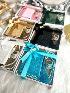 six different colored boxes with pearls and bows on them sitting on a white furnishing