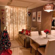 a living room filled with furniture and a christmas tree in front of a tv mounted on a wall