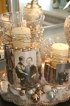 two glass vases filled with candles and pictures