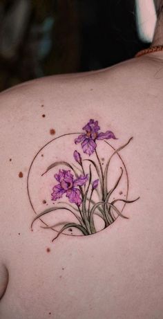 a woman's back with purple flowers on it