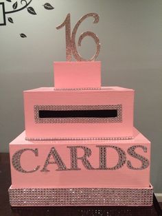 a pink cake that has the number sixteen on it and is decorated with silver glitter