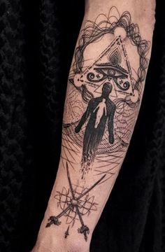 a person with a tattoo on their arm holding a knife and an eye in the middle