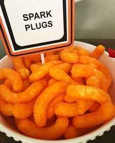 a white bowl filled with fried food next to a sign that says spark plugs