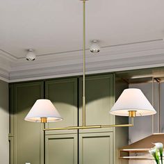 a kitchen with green cabinets and two lamps