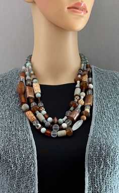 One-of-a-kind multi-strand statement necklace. Beads: 3-strands of mixed beads, including amazonite, carved wood and bone, vintage lucite, matte quartz, Afghan fire-torched copper, sterling silver Dimensions: approximately 26" + 3.5" extender Make a statement with this stunning necklace! ﻿Free Shipping ﻿Refund Policy Lampwork Bead Jewelry, Bold Statement Jewelry, Boho Style Necklaces, Wearable Art Jewelry, Beaded Jewelry Necklaces, Silver Necklace Statement, Portrait References, Necklace Beads, Beaded Statement Necklace