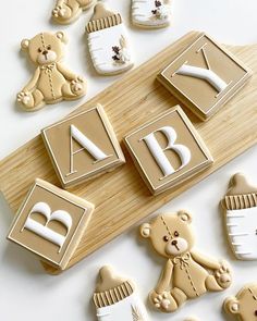 decorated cookies with letters and teddy bears on a cutting board