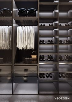 an organized walk - in closet with white shirts and shoes