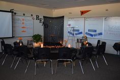 a room filled with black chairs and tables covered in whiteboards next to each other