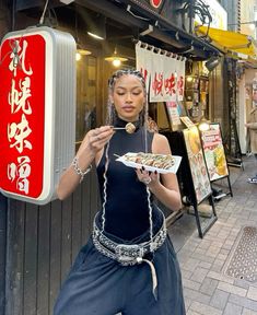 a woman holding a plate of food in front of a store