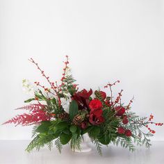 a white vase filled with red and white flowers