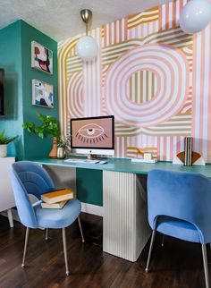 two blue chairs sitting in front of a desk with a computer on top of it