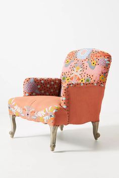 an upholstered chair with flowers and dots on it