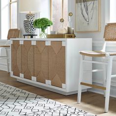 a white and beige sideboard in a living room with two chairs next to it