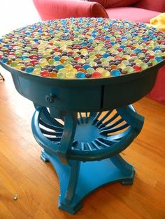 a table made out of plastic balls on top of a hard wood floor with red couch in the background