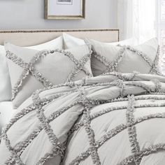 the comforter is made up with ruffled trims and white bed linens