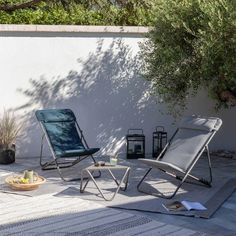 two lawn chairs sitting next to each other on a patio