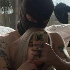 a man with tattoos on his back taking a selfie