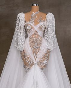 the back of a wedding dress with an intricate lace and beaded design on it