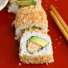 sushi rolls on a red plate with chopsticks