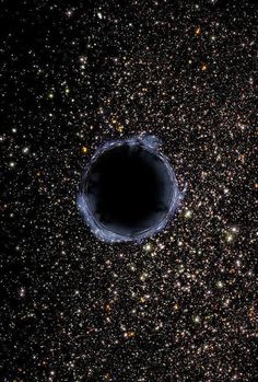 a black hole in the sky surrounded by stars