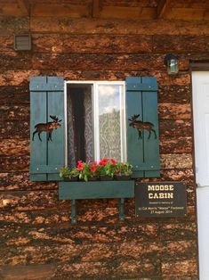 an old building with blue shutters and flowers on the window sill