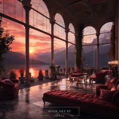 a living room filled with red couches next to large windows at sunset or dawn