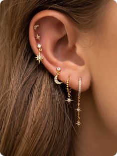 a woman's ear with stars and moon earrings