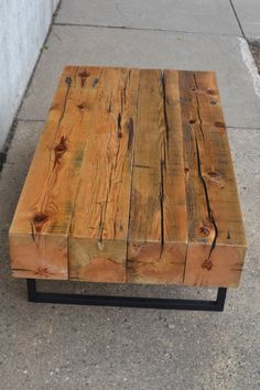 a wooden bench sitting on top of a sidewalk