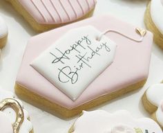 some decorated cookies are sitting on a table with pink frosting and white icing