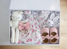 a white box with pink shoes and stuffed animals