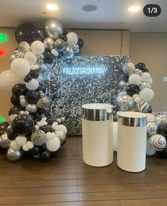 black and white balloons are on display in front of a wall with the words congratulations