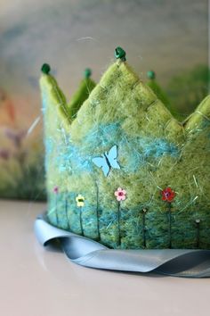 a green felt crown sitting on top of a table