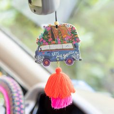 a car keychain hanging from the front of a vehicle with flowers on it