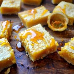 several pieces of cake sitting on top of a wooden cutting board with honey drizzled around them