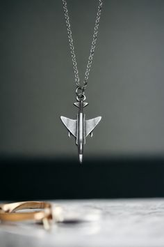 ✈️ F4 Phantom Fighter Jet Necklace - Soar with the Spirit of Aviation! ✈️ Take flight with our F4 Phantom Fighter Jet Necklace--a silver-plated pendant that encapsulates the power and grace of aviation. This isn't just jewelry; it's a statement--an accessory for aviation enthusiasts, pilots, and fans of the iconic F4 Phantom. ✨ Key Features: Silver-plated fighter jet pendant inspired by the F4 Phantom Unisex and adjustable, perfect for aviation enthusiasts Unique charm capturing the essence of a F4 Phantom, Gifts For History Buffs, Peace Sign Necklace, Necklace Stand, Hand Necklace, Hand Of Fatima, Fancy Jewellery, Silver Plated Necklace, Unisex Accessories