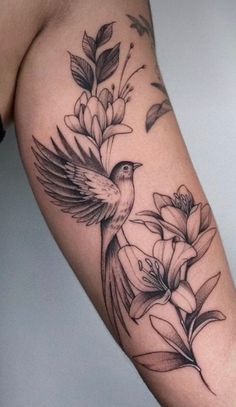 a bird and flowers tattoo on the arm