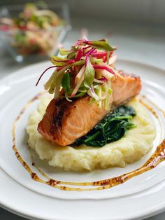 a white plate topped with mashed potatoes and salmon