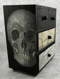 a wooden box with a skull painted on it's side and drawers in the front