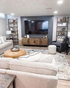 a living room filled with furniture and a flat screen tv mounted on the wall above it