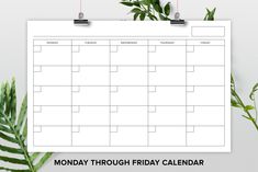 the monday through friday calendar is hanging on a white wall next to some green leaves