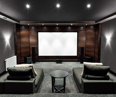 an empty room with two couches and a large screen