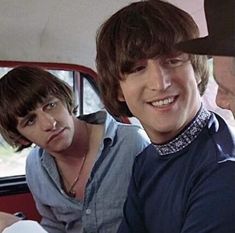 three young men are sitting in the back seat of a car and one is smiling