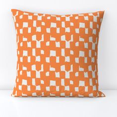 an orange pillow with white squares on it