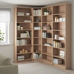 a living room filled with lots of wooden bookshelves next to a white couch