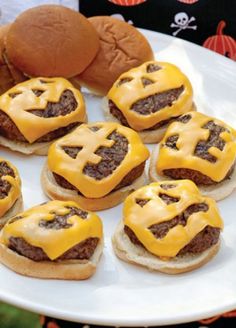 some hamburgers with cheese on them are sitting on a plate next to a stuffed animal