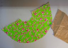 two pieces of green paper with candy canes on them next to a brown bag