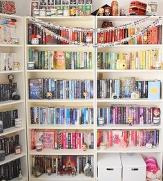 a book shelf filled with lots of books on top of white shelving unit units