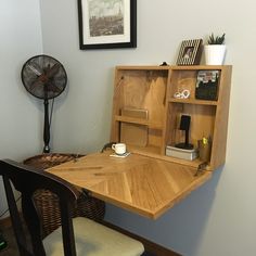 a wooden desk with a fan on the wall