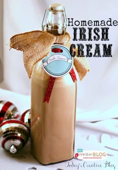 homemade irish cream in a glass bottle with a bow on the top and ornaments around it